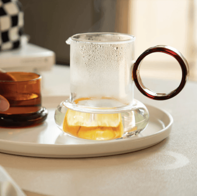 http://huemabe.com/cdn/shop/files/glass-pitcher-teapot-with-cup-lid-huemabe-creative-home-decor-1.png?v=1683886216